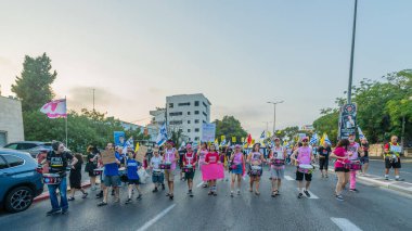 Hayfa, İsrail - 09 Ağustos 2025: İnsanlar savaşın sona ermesi, rehine anlaşmasının tamamlanması ve yeni seçimler çağrısında bulunan bir protesto yürüyüşüne (Pembe Cephe Grubu) katılıyor. Hayfa, İsrail