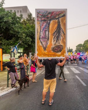 Hayfa, İsrail - 09 Ağustos 2025: Çeşitli tabelaları ve bayrakları olan insanlar, savaşın sona ermesi, rehine anlaşmasının tamamlanması ve yeni seçimlerin başlatılması için düzenlenen protesto mitingine katıldılar. Hayfa, İsrail