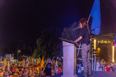 Hayfa, İsrail - 09 Ağustos 2025: Nava Rozolyo, savaşın sona ermesi, rehine anlaşmasının tamamlanması ve yeni seçimler için düzenlenen protesto mitinginin bir parçası olarak kalabalığa seslendi. Hayfa, İsrail