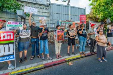 Hayfa, İsrail - 16 Ağustos 2025: İnsanlar çeşitli işaret ve bayraklarla bir protesto yürüyüşüne katılıyor, savaşın sona ermesi ve rehine anlaşmasının tamamlanması çağrısında bulunuyorlar. Hayfa, İsrail