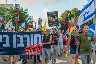 Hayfa, İsrail - 16 Ağustos 2025: Çeşitli tabelaları ve bayrakları olan insanlar, savaşın sona ermesi, rehine anlaşmasının tamamlanması ve yeni seçimlerin başlatılması için düzenlenen protesto mitingine katıldılar. Hayfa, İsrail