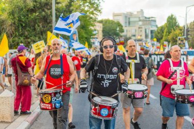 Hayfa, İsrail - 16 Ağustos 2025: İnsanlar savaşın sona ermesi, rehine anlaşmasının tamamlanması ve yeni seçimler çağrısında bulunan bir protesto yürüyüşüne (Pembe Cephe Grubu) katılıyor. Hayfa, İsrail