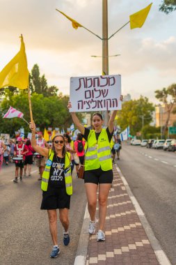 Hayfa, İsrail - 16 Ağustos 2025: Çeşitli tabelaları ve bayrakları olan insanlar, savaşın sona ermesi, rehine anlaşmasının tamamlanması ve yeni seçimlerin başlatılması için düzenlenen protesto mitingine katıldılar. Hayfa, İsrail