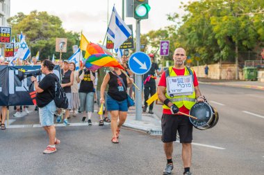 Hayfa, İsrail - 16 Ağustos 2025: Çeşitli tabelaları ve bayrakları olan insanlar, savaşın sona ermesi, rehine anlaşmasının tamamlanması ve yeni seçimlerin başlatılması için düzenlenen protesto mitingine katıldılar. Hayfa, İsrail