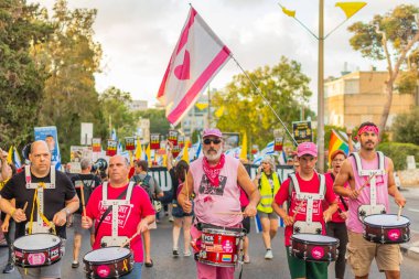 Hayfa, İsrail - 16 Ağustos 2025: İnsanlar savaşın sona ermesi, rehine anlaşmasının tamamlanması ve yeni seçimler çağrısında bulunan bir protesto yürüyüşüne (Pembe Cephe Grubu) katılıyor. Hayfa, İsrail