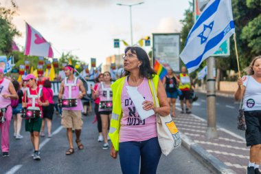 Hayfa, İsrail - 16 Ağustos 2025: Çeşitli tabelaları ve bayrakları olan insanlar, savaşın sona ermesi, rehine anlaşmasının tamamlanması ve yeni seçimlerin başlatılması için düzenlenen protesto mitingine katıldılar. Hayfa, İsrail