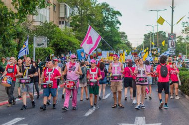 Hayfa, İsrail - 16 Ağustos 2025: İnsanlar savaşın sona ermesi, rehine anlaşmasının tamamlanması ve yeni seçimler çağrısında bulunan bir protesto yürüyüşüne (Pembe Cephe Grubu) katılıyor. Hayfa, İsrail