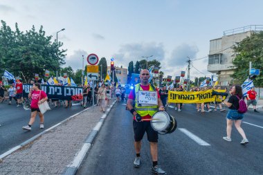 Hayfa, İsrail - 16 Ağustos 2025: Çeşitli tabelaları ve bayrakları olan insanlar, savaşın sona ermesi, rehine anlaşmasının tamamlanması ve yeni seçimlerin başlatılması için düzenlenen protesto mitingine katıldılar. Hayfa, İsrail