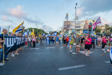 Hayfa, İsrail - 16 Ağustos 2025: Çeşitli tabelaları ve bayrakları olan insanlar, savaşın sona ermesi, rehine anlaşmasının tamamlanması ve yeni seçimlerin başlatılması için düzenlenen protesto mitingine katıldılar. Hayfa, İsrail