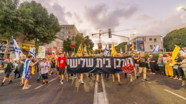 Hayfa, İsrail - 16 Ağustos 2025: Çeşitli tabelaları ve bayrakları olan insanlar, savaşın sona ermesi, rehine anlaşmasının tamamlanması ve yeni seçimlerin başlatılması için düzenlenen protesto mitingine katıldılar. Hayfa, İsrail