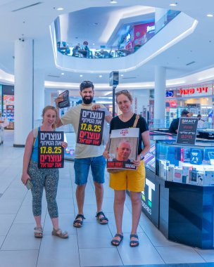 Hayfa, İsrail - 17 Ağustos 2025: AVM protestosu, İsrail 'in Hayfa kentinde düzenlenen Gazze Rehine Eylem Günü kapsamında insanlar rehineleri destekleyen pankartlarla yürüyor