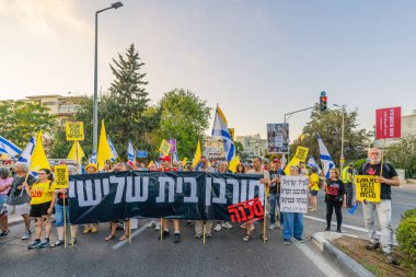 Hayfa, İsrail - 23 Ağustos 2025: Çeşitli tabelaları ve bayrakları olan insanlar, savaşın sona ermesi, rehine anlaşmasının tamamlanması ve yeni seçimler için düzenlenen protesto mitingine katıldılar. Hayfa, İsrail