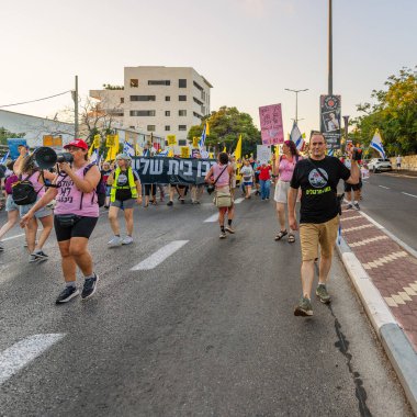 Hayfa, İsrail - 23 Ağustos 2025: Çeşitli tabelaları ve bayrakları olan insanlar, savaşın sona ermesi, rehine anlaşmasının tamamlanması ve yeni seçimler için düzenlenen protesto mitingine katıldılar. Hayfa, İsrail