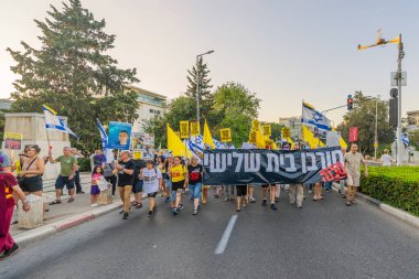 Hayfa, İsrail - 23 Ağustos 2025: Çeşitli tabelaları ve bayrakları olan insanlar, savaşın sona ermesi, rehine anlaşmasının tamamlanması ve yeni seçimler için düzenlenen protesto mitingine katıldılar. Hayfa, İsrail