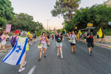 Hayfa, İsrail - 23 Ağustos 2025: Çeşitli tabelaları ve bayrakları olan insanlar, savaşın sona ermesi, rehine anlaşmasının tamamlanması ve yeni seçimler için düzenlenen protesto mitingine katıldılar. Hayfa, İsrail