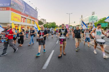 Hayfa, İsrail - 23 Ağustos 2025: Çeşitli tabelaları ve bayrakları olan insanlar, savaşın sona ermesi, rehine anlaşmasının tamamlanması ve yeni seçimler için düzenlenen protesto mitingine katıldılar. Hayfa, İsrail