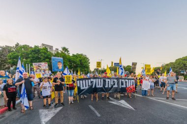 Hayfa, İsrail - 23 Ağustos 2025: Çeşitli tabelaları ve bayrakları olan insanlar, savaşın sona ermesi, rehine anlaşmasının tamamlanması ve yeni seçimler için düzenlenen protesto mitingine katıldılar. Hayfa, İsrail