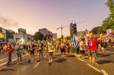 Hayfa, İsrail - 23 Ağustos 2025: Çeşitli tabelaları ve bayrakları olan insanlar, savaşın sona ermesi, rehine anlaşmasının tamamlanması ve yeni seçimler için düzenlenen protesto mitingine katıldılar. Hayfa, İsrail
