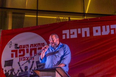 Hayfa, İsrail - 23 Ağustos 2025: Tomer Ben Hamo, savaşın sona ermesi, rehine anlaşmasının tamamlanması ve yeni seçimler için düzenlenen protesto mitinginin bir parçası olarak kalabalığa seslendi. Hayfa, İsrail