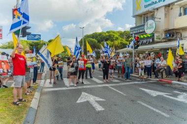 Hayfa, İsrail - 26 Ağustos 2025: İnsanlar çeşitli tabelalarla protesto ediyor ve İsrail 'in Hayfa kentinde düzenlenen Gazze Rehinesi Protesto Günü kapsamında yolu kapatıyorlar.