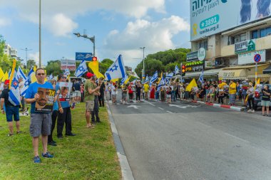 Hayfa, İsrail - 26 Ağustos 2025: İnsanlar çeşitli tabelalarla protesto ediyor ve İsrail 'in Hayfa kentinde düzenlenen Gazze Rehinesi Protesto Günü kapsamında yolu kapatıyorlar.
