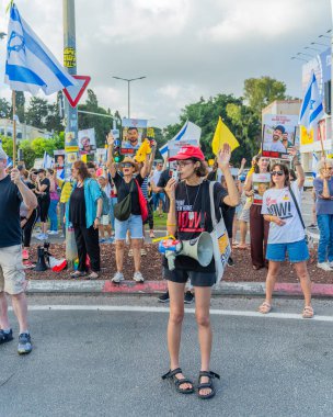 Hayfa, İsrail - 26 Ağustos 2025: İnsanlar çeşitli tabelalarla protesto ediyor ve İsrail 'in Hayfa kentinde düzenlenen Gazze Rehinesi Protesto Günü kapsamında yolu kapatıyorlar.