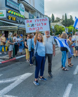 Hayfa, İsrail - 26 Ağustos 2025: İnsanlar çeşitli tabelalarla protesto ediyor ve İsrail 'in Hayfa kentinde düzenlenen Gazze Rehinesi Protesto Günü kapsamında yolu kapatıyorlar.