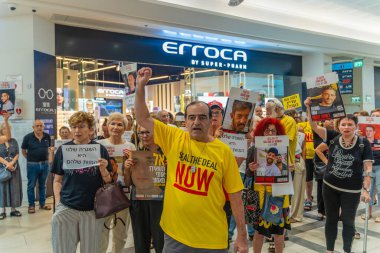 Hayfa, İsrail - 26 Ağustos 2025: Alışveriş merkezi protestosu, İsrail 'in Hayfa kentindeki Gazze Rehine Anlaşması için ülke çapında düzenlenen bir protesto gününün bir parçası olarak rehineleri destekleyen pankartlarla yürüyen insanlar
