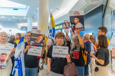 Hayfa, İsrail - 26 Ağustos 2025: Alışveriş merkezi protestosu, İsrail 'in Hayfa kentindeki Gazze Rehine Anlaşması için ülke çapında düzenlenen bir protesto gününün bir parçası olarak rehineleri destekleyen pankartlarla yürüyen insanlar