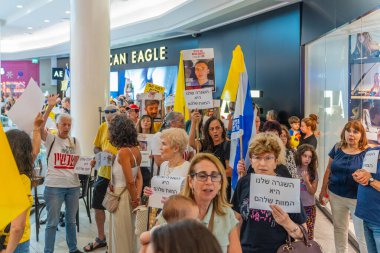 Hayfa, İsrail - 26 Ağustos 2025: Alışveriş merkezi protestosu, İsrail 'in Hayfa kentindeki Gazze Rehine Anlaşması için ülke çapında düzenlenen bir protesto gününün bir parçası olarak rehineleri destekleyen pankartlarla yürüyen insanlar