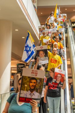 Hayfa, İsrail - 26 Ağustos 2025: Alışveriş merkezi protestosu, İsrail 'in Hayfa kentindeki Gazze Rehine Anlaşması için ülke çapında düzenlenen bir protesto gününün bir parçası olarak rehineleri destekleyen pankartlarla yürüyen insanlar