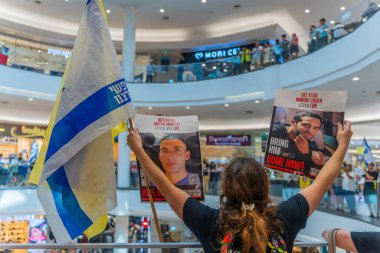 Hayfa, İsrail - 26 Ağustos 2025: Alışveriş merkezi protestosu, İsrail 'in Hayfa kentindeki Gazze Rehine Anlaşması için ülke çapında düzenlenen bir protesto gününün bir parçası olarak rehineleri destekleyen pankartlarla yürüyen insanlar