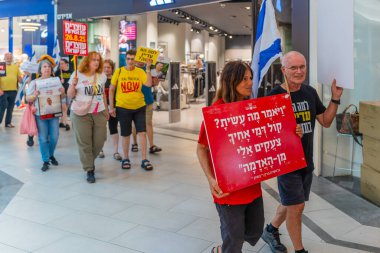 Hayfa, İsrail - 26 Ağustos 2025: Alışveriş merkezi protestosu, İsrail 'in Hayfa kentindeki Gazze Rehine Anlaşması için ülke çapında düzenlenen bir protesto gününün bir parçası olarak rehineleri destekleyen pankartlarla yürüyen insanlar