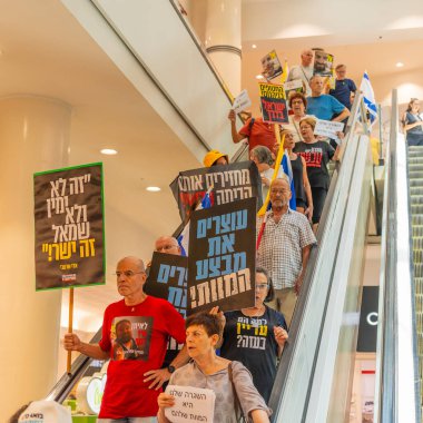 Hayfa, İsrail - 26 Ağustos 2025: Alışveriş merkezi protestosu, İsrail 'in Hayfa kentindeki Gazze Rehine Anlaşması için ülke çapında düzenlenen bir protesto gününün bir parçası olarak rehineleri destekleyen pankartlarla yürüyen insanlar