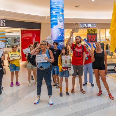 Hayfa, İsrail - 26 Ağustos 2025: Alışveriş merkezi protestosu, İsrail 'in Hayfa kentindeki Gazze Rehine Anlaşması için ülke çapında düzenlenen bir protesto gününün bir parçası olarak rehineleri destekleyen pankartlarla yürüyen insanlar