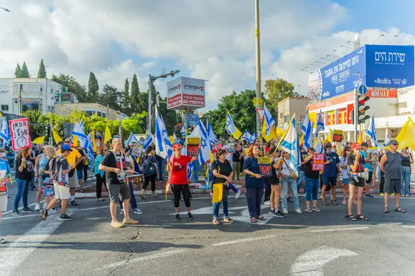 Hayfa, İsrail - 26 Ağustos 2025: İnsanlar çeşitli tabelalarla protesto ediyor ve İsrail 'in Hayfa kentinde düzenlenen Gazze Rehinesi Protesto Günü kapsamında yolu kapatıyorlar.
