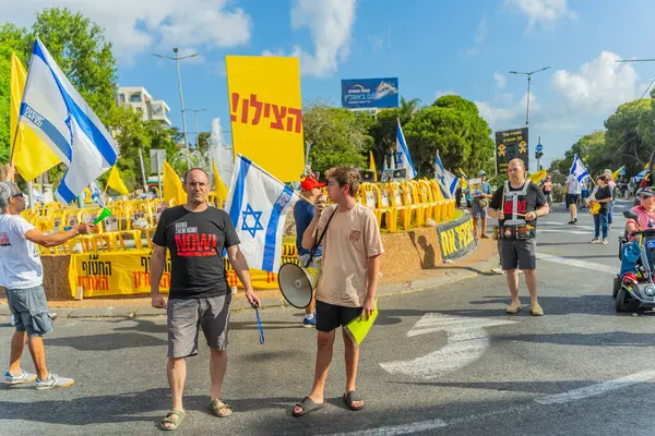 Hayfa, İsrail - 26 Ağustos 2025: İnsanlar çeşitli tabelalarla protesto ediyor ve İsrail 'in Hayfa kentinde düzenlenen Gazze Rehinesi Protesto Günü kapsamında yolu kapatıyorlar.