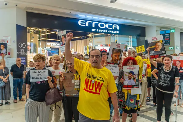 Hayfa, İsrail - 26 Ağustos 2025: Alışveriş merkezi protestosu, İsrail 'in Hayfa kentindeki Gazze Rehine Anlaşması için ülke çapında düzenlenen bir protesto gününün bir parçası olarak rehineleri destekleyen pankartlarla yürüyen insanlar