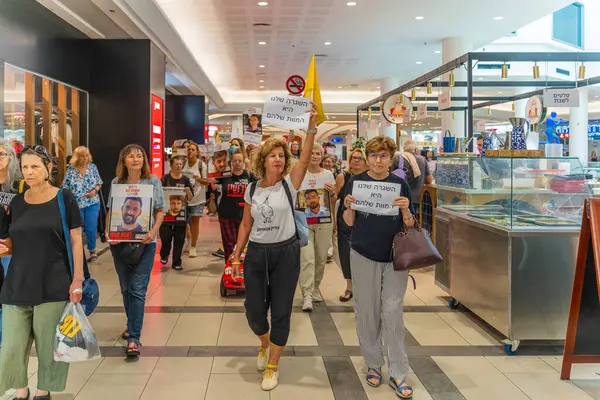 Hayfa, İsrail - 26 Ağustos 2025: Alışveriş merkezi protestosu, İsrail 'in Hayfa kentindeki Gazze Rehine Anlaşması için ülke çapında düzenlenen bir protesto gününün bir parçası olarak rehineleri destekleyen pankartlarla yürüyen insanlar