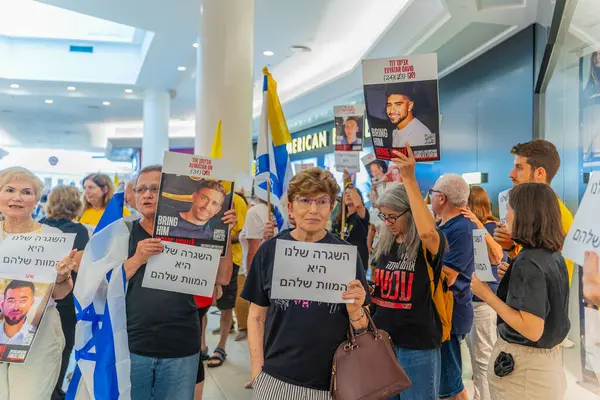 Hayfa, İsrail - 26 Ağustos 2025: Alışveriş merkezi protestosu, İsrail 'in Hayfa kentindeki Gazze Rehine Anlaşması için ülke çapında düzenlenen bir protesto gününün bir parçası olarak rehineleri destekleyen pankartlarla yürüyen insanlar