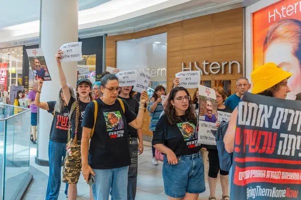 Hayfa, İsrail - 26 Ağustos 2025: Alışveriş merkezi protestosu, İsrail 'in Hayfa kentindeki Gazze Rehine Anlaşması için ülke çapında düzenlenen bir protesto gününün bir parçası olarak rehineleri destekleyen pankartlarla yürüyen insanlar
