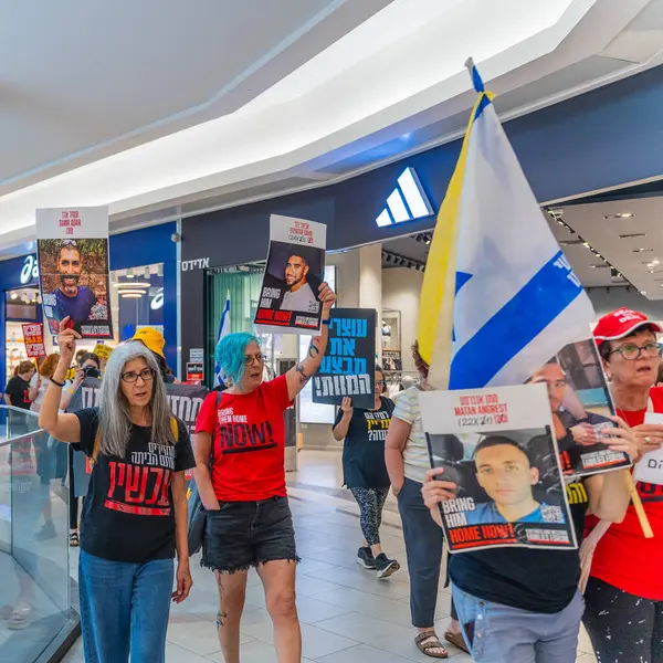 Hayfa, İsrail - 26 Ağustos 2025: Alışveriş merkezi protestosu, İsrail 'in Hayfa kentindeki Gazze Rehine Anlaşması için ülke çapında düzenlenen bir protesto gününün bir parçası olarak rehineleri destekleyen pankartlarla yürüyen insanlar