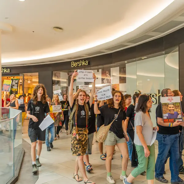 Hayfa, İsrail - 26 Ağustos 2025: Alışveriş merkezi protestosu, İsrail 'in Hayfa kentindeki Gazze Rehine Anlaşması için ülke çapında düzenlenen bir protesto gününün bir parçası olarak rehineleri destekleyen pankartlarla yürüyen insanlar
