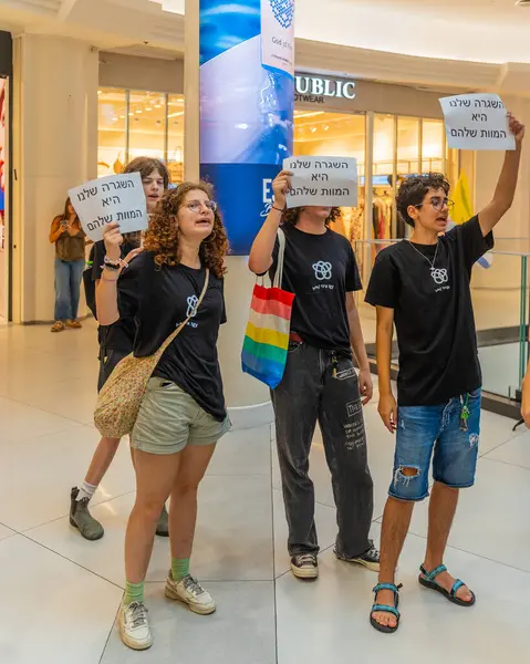 Hayfa, İsrail - 26 Ağustos 2025: Alışveriş merkezi protestosu, İsrail 'in Hayfa kentindeki Gazze Rehine Anlaşması için ülke çapında düzenlenen bir protesto gününün bir parçası olarak rehineleri destekleyen pankartlarla yürüyen insanlar