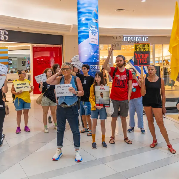 Hayfa, İsrail - 26 Ağustos 2025: Alışveriş merkezi protestosu, İsrail 'in Hayfa kentindeki Gazze Rehine Anlaşması için ülke çapında düzenlenen bir protesto gününün bir parçası olarak rehineleri destekleyen pankartlarla yürüyen insanlar