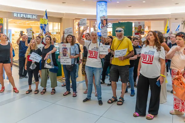 Hayfa, İsrail - 26 Ağustos 2025: Alışveriş merkezi protestosu, İsrail 'in Hayfa kentindeki Gazze Rehine Anlaşması için ülke çapında düzenlenen bir protesto gününün bir parçası olarak rehineleri destekleyen pankartlarla yürüyen insanlar