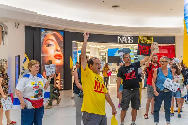 Hayfa, İsrail - 26 Ağustos 2025: Alışveriş merkezi protestosu, İsrail 'in Hayfa kentindeki Gazze Rehine Anlaşması için ülke çapında düzenlenen bir protesto gününün bir parçası olarak rehineleri destekleyen pankartlarla yürüyen insanlar