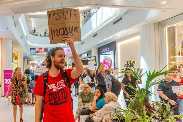 Hayfa, İsrail - 26 Ağustos 2025: Alışveriş merkezi protestosu, İsrail 'in Hayfa kentindeki Gazze Rehine Anlaşması için ülke çapında düzenlenen bir protesto gününün bir parçası olarak rehineleri destekleyen pankartlarla yürüyen insanlar