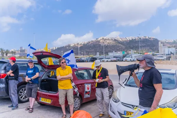 Hayfa, İsrail - 26 Ağustos 2025: İnsanlar, İsrail 'in Hayfa kentinde düzenlenen Gazze Rehinesi Protesto Günü kapsamında, dekore edilmiş arabalardan oluşan bir protesto konvoyu hazırlıyorlar.
