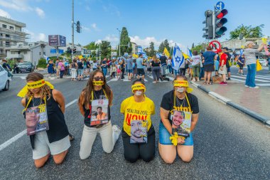 Hayfa, İsrail - 26 Ağustos 2025: İnsanlar, İsrail 'in Hayfa kentindeki Gazze Rehine Anlaşması için ülke çapındaki bir protesto gününün rehin alınmış ve gözleri bağlı sembolik bir sokak gösterisini gerçekleştirdi.
